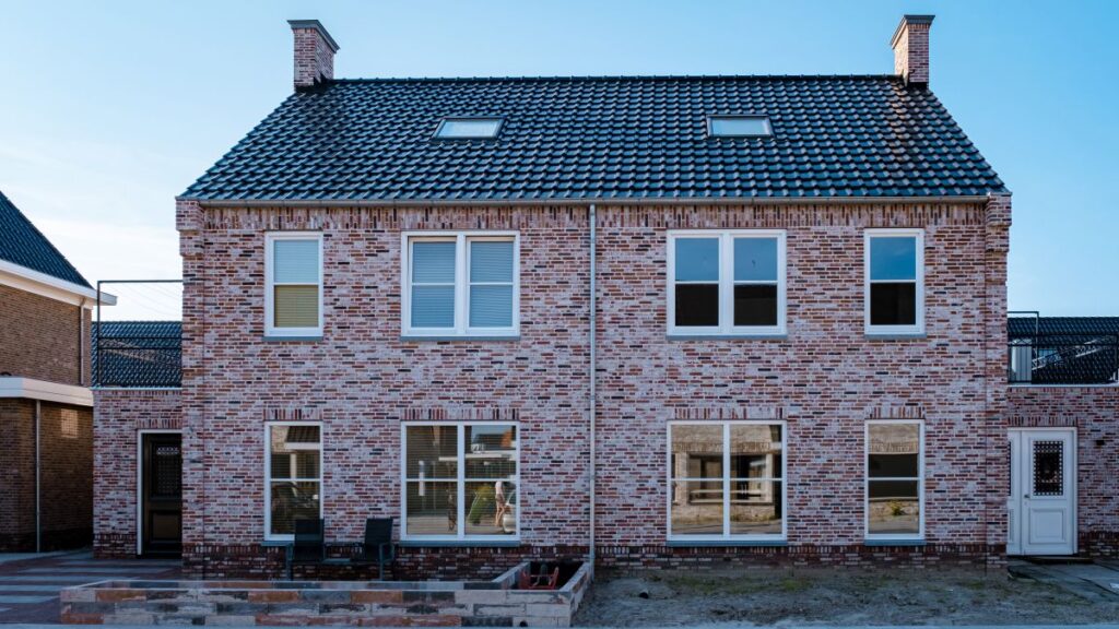 Doppelhaus mit weißen und roten Klinkersteinen und weißen Fensterrahmen