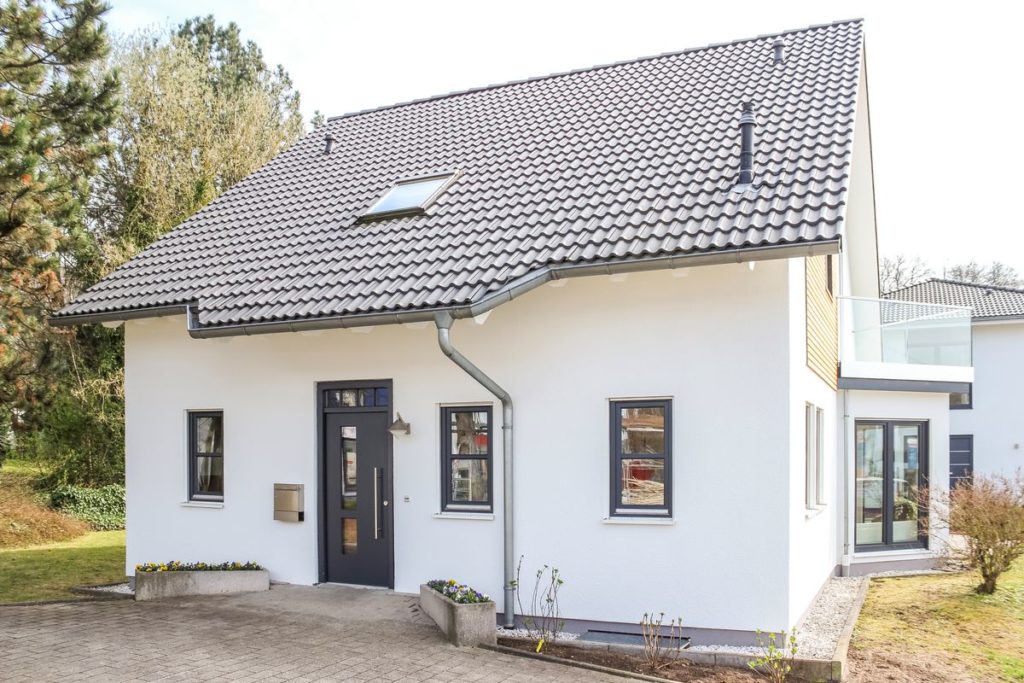 Musterhaus Bad Vilbel - Ein Haus mit Bäumen im Hintergrund - Einfamilienhaus