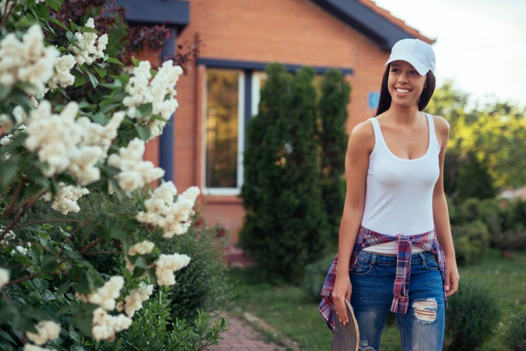 Welche Aspekte sind Hausbesitzern in spe wichtig? Hausbau Helden Frau vor ihrem neuen Zuhause