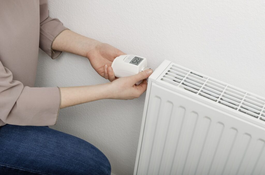 Bussysteme Haus: smarte Technik fürs Zuhause Hausbau Helden Person verstellt das Thermostat an der Heizung