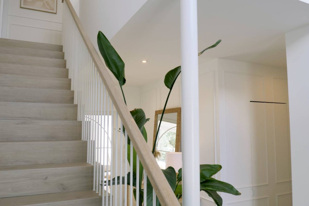 a staircase with a white railing and a plant