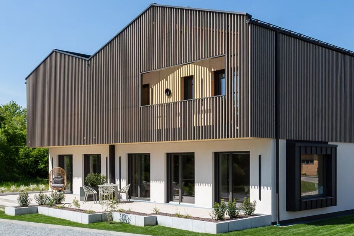 Außenansicht mit Terrasse und Lamellen Holzfassade