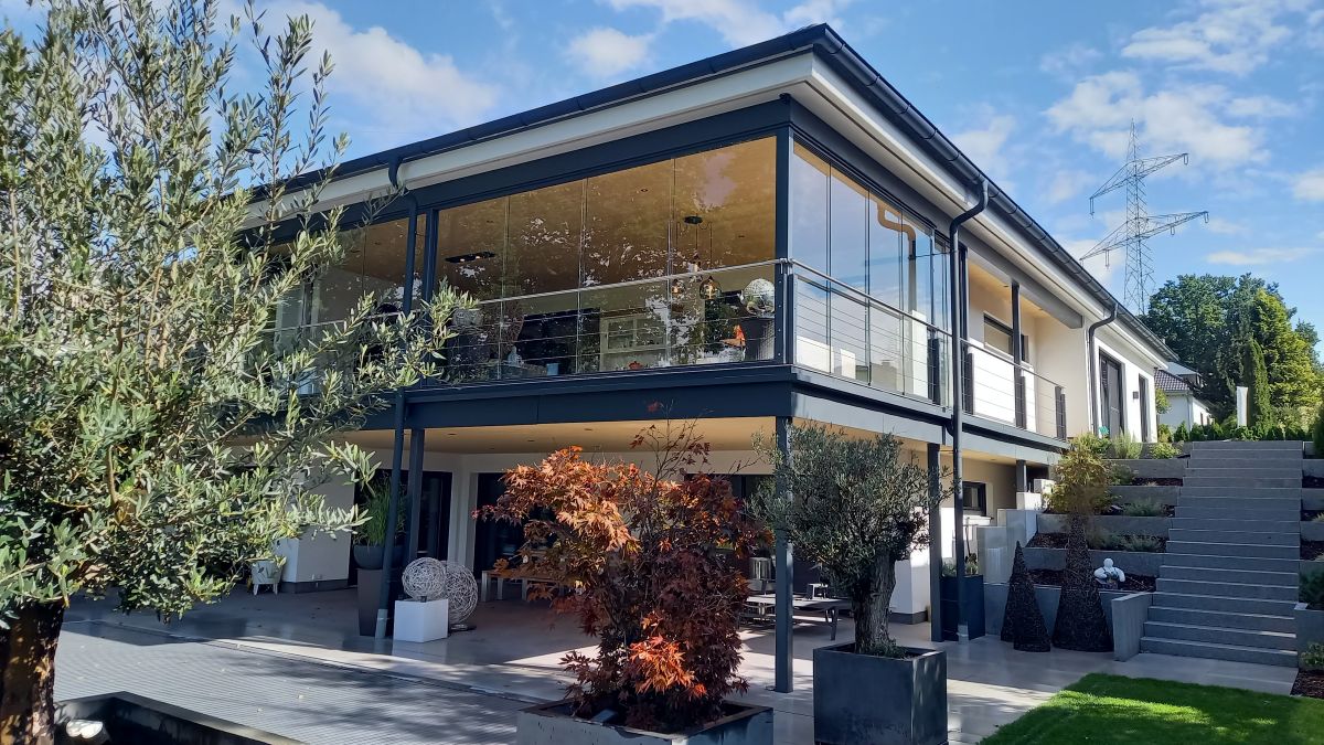 Lehner Haus individueller Bungalow am Hang Ansicht seitlich mit Glasfront und Garten mit Steintreppe