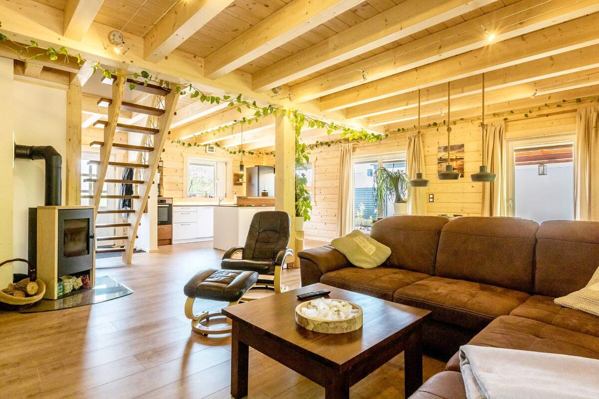 Blockhaus Aalborg helles Wohnzimmer mit Holzwänden und braunen Möbeln