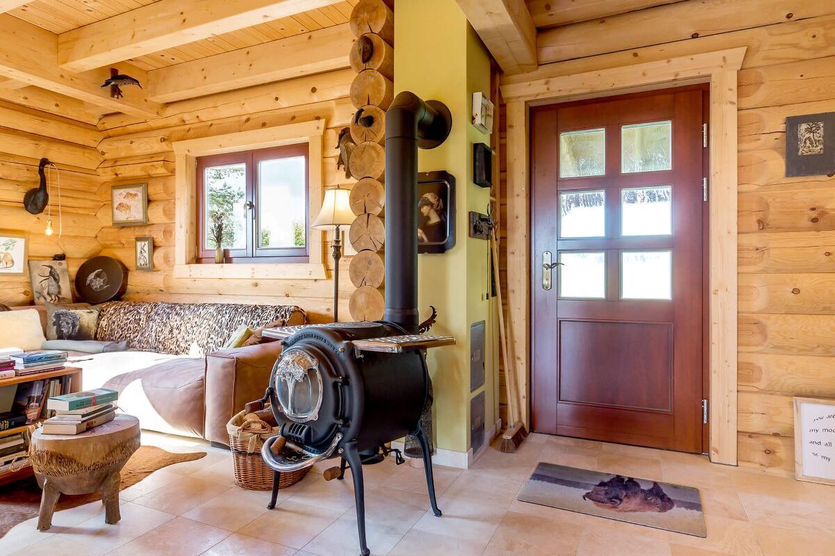 LéonWood Blockhaus Husky Wohnzimmer mit Ofen und rustikaler Einrichtung