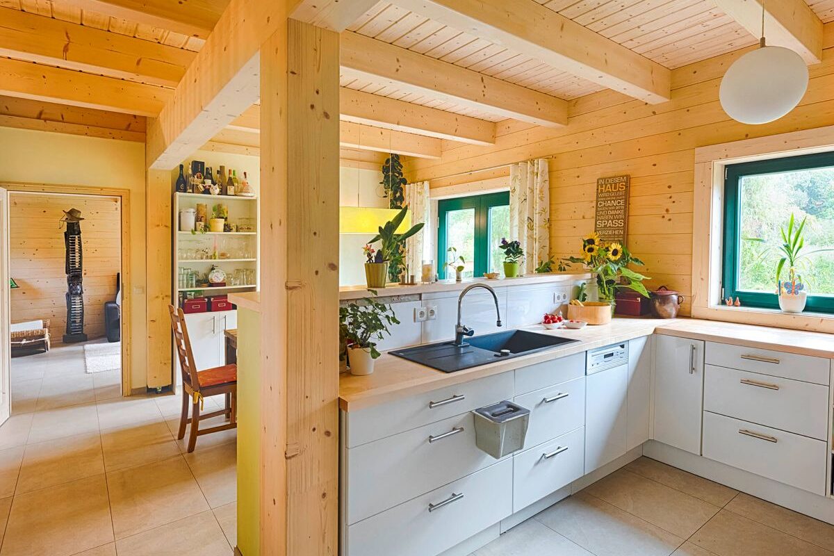 Blockhaus Alpina One Küche und Essbereich mit Holzdecke