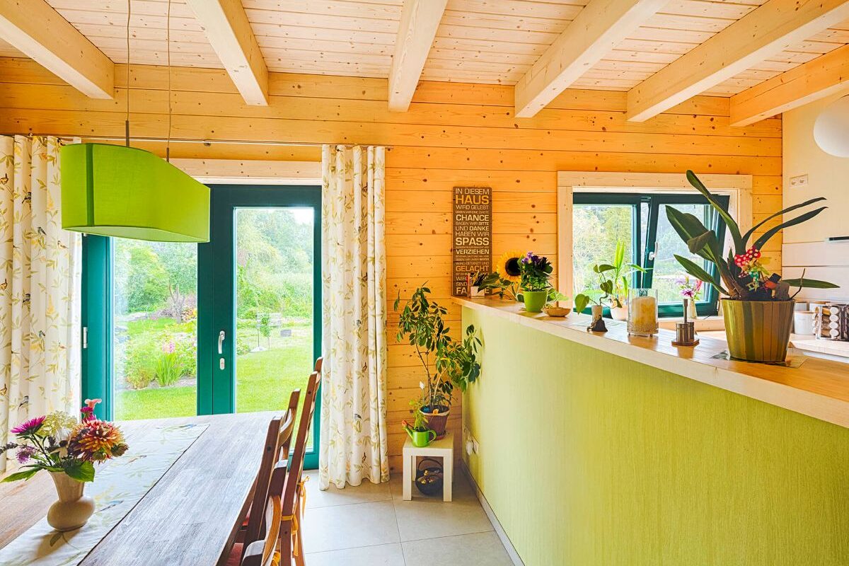 Blockhaus Alpina One Küche und Essbereich mit Holzdecke und Theke