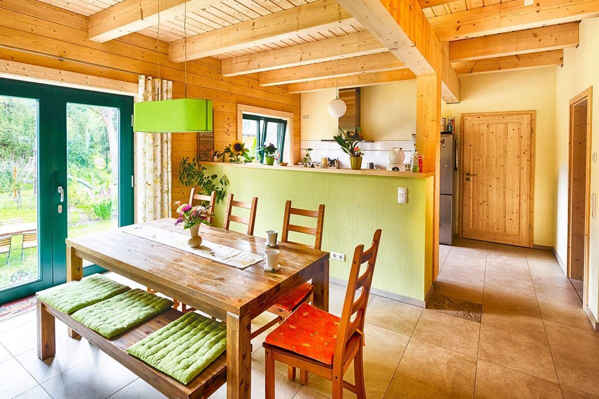 Blockhaus Alpina One Küche und Essbereich mit Holzdecke und Tresen