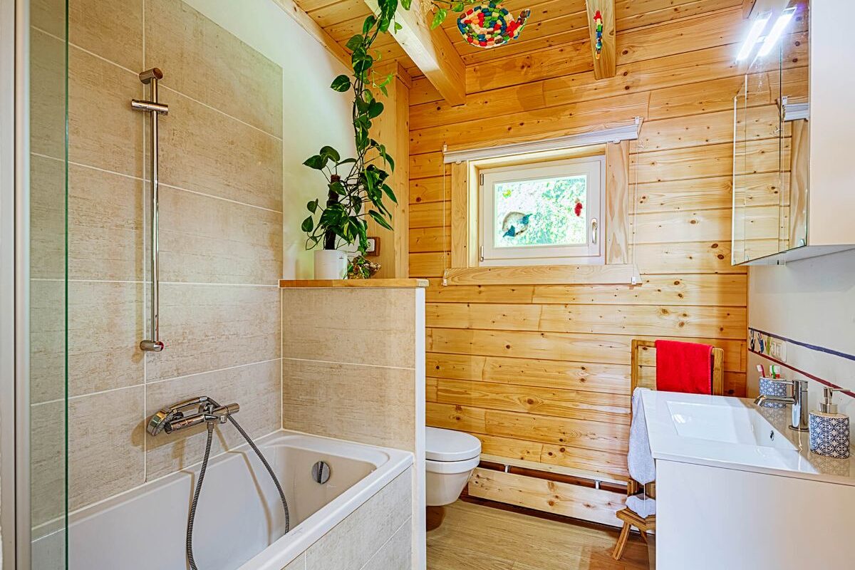 Blockhaus Flatwood Green 90 Badezimmer mit Badewanne und Holzwand