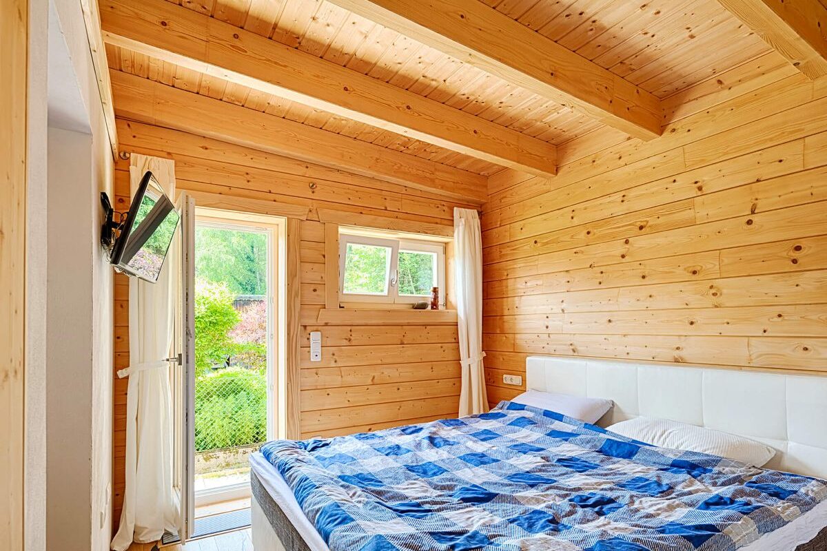 Blockhaus Flatwood Green 90 Schlafzimmer mit Holzwänden und Holzdecke