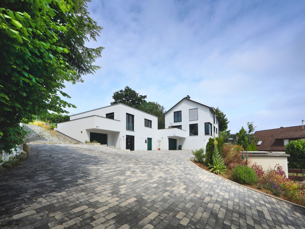 Mehrgenerationenhaus Calw von myMassivhaus mit breiter Einfahrt und zwei Häusern, eins mit Flachdach