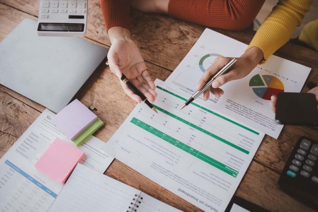 Blätter mit Zahlen und Taschenrechner auf dem Tisch