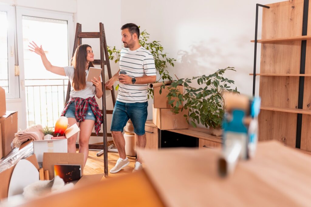 Pärchen steht während Umzug im Wohnzimmer