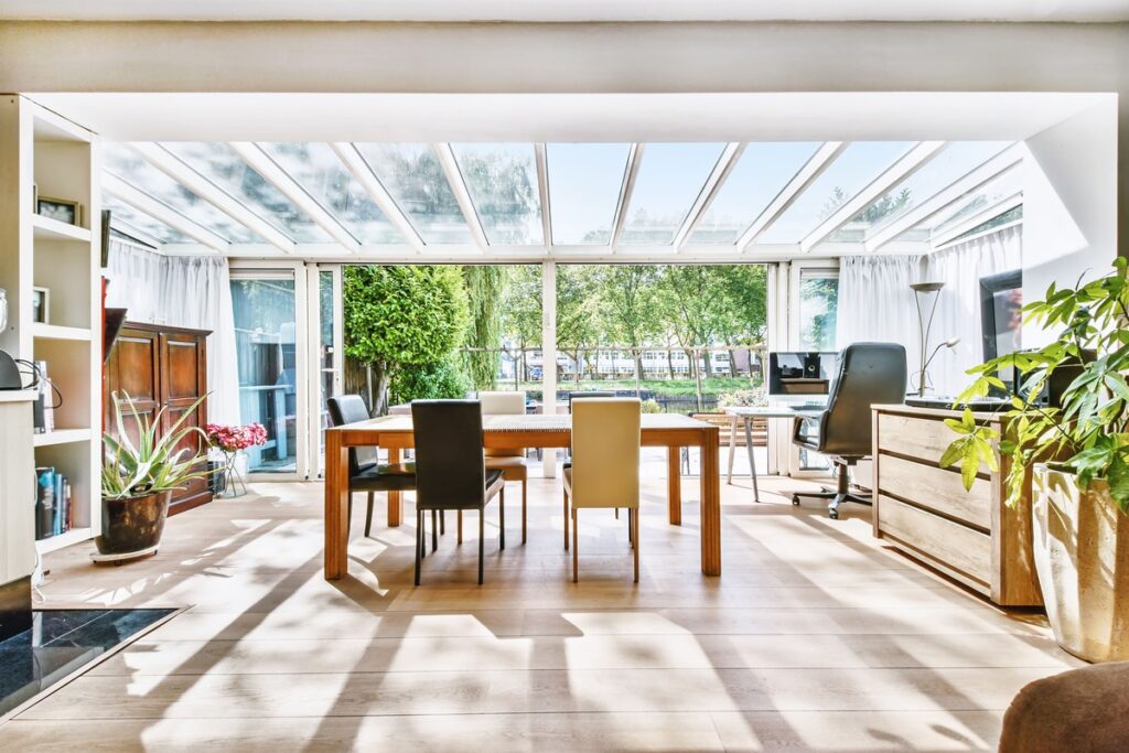 Wintergarten als erweiterter Wohnraum mit Tisch, Stühlen & Möbel